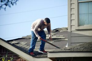 Homeowner examining roof shingles and gutters from the ground after a heavy storm.